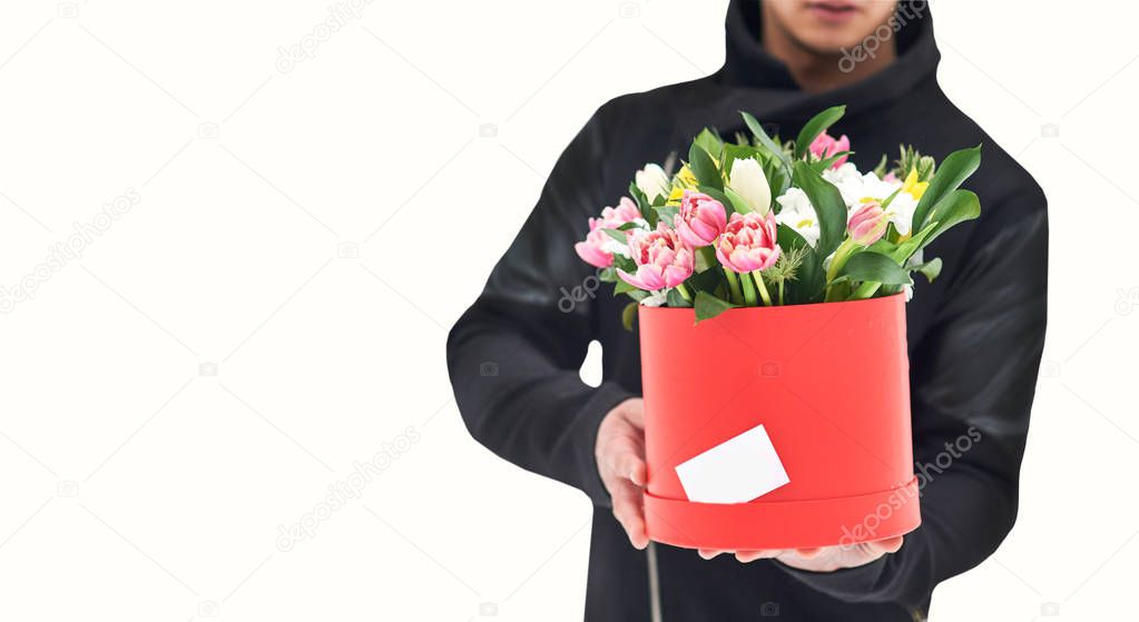 man holding red gift box with beautiful bouquet of blooming flowers, romantic moment, woman day and Valentines Day. Isolated with clipping path. delivery courier man delivering box with flowers.