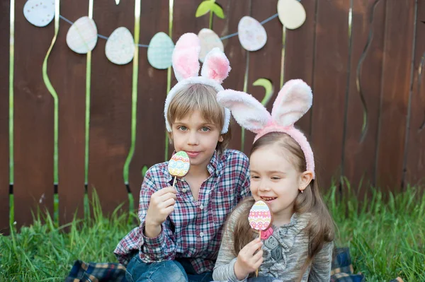少女と少年は イースターの卵の形をしたジンジャーブレッド クッキーを食べる イースターのお祝い イースターエッグで笑う子供狩り — ストック写真