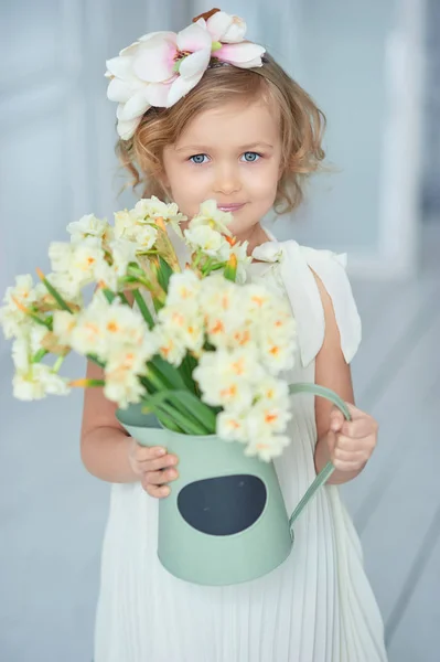 女孩手捧着水仙 可爱的微笑小女孩为她的母亲在母亲节举行花 — 图库照片