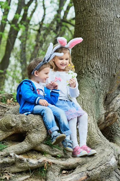 Cute funny girl and boy with Easter eggs at park. easter concept. Children playing with easter eggs on Easter day. Family holiday