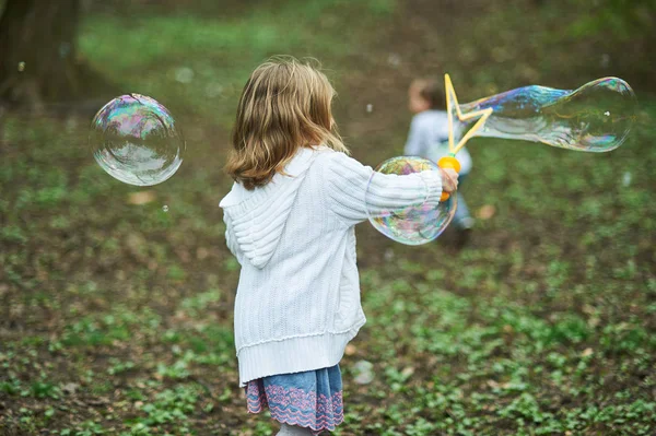 女孩玩巨大的肥皂泡 儿童吹大气泡 — 图库照片