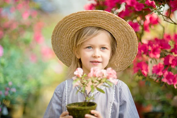 Niño con cesta de flores. niña sosteniendo flores rosadas — Foto de Stock