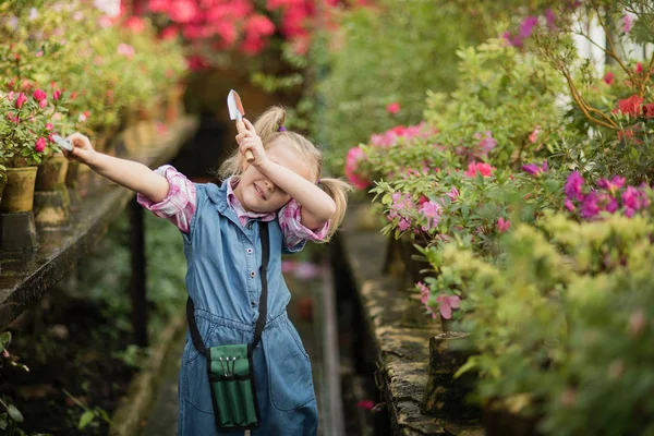 Toddler with flower basket. girl holding pink flowers Stock Photo