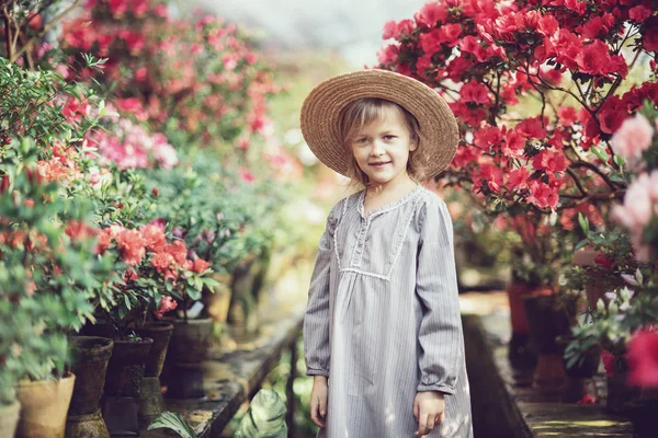 带花篮的幼儿。拿着粉红色花朵的女孩 — 图库照片