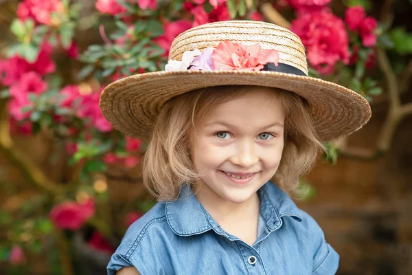 Toddler with flower basket. girl holding pink flowers — Stock Photo, Image