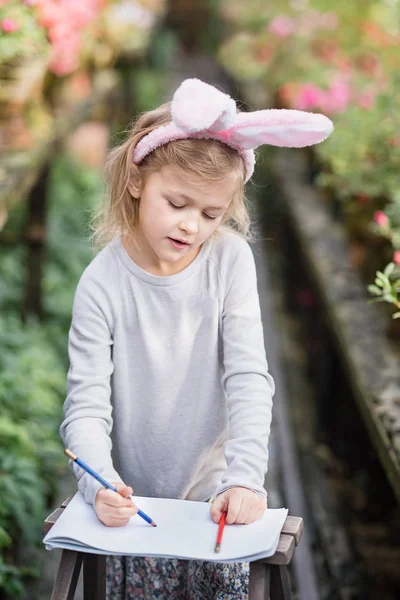 Gadis lucu dengan telinga kelinci paskah di taman. konsep easter. Tertawa anak di Paskah berburu telur — Stok Foto