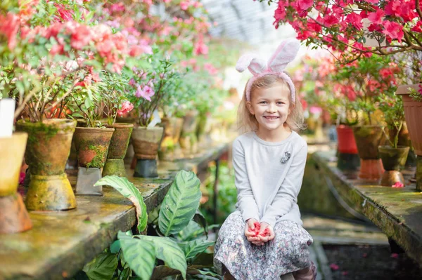 Linda chica divertida con orejas de conejo de Pascua en el jardín. concepto de Pascua. Riendo niño en la búsqueda de huevos de Pascua . —  Fotos de Stock