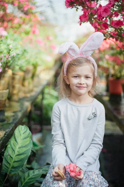 Linda chica divertida con orejas de conejo de Pascua en el jardín. concepto de Pascua. Riendo niño en la búsqueda de huevos de Pascua . —  Fotos de Stock