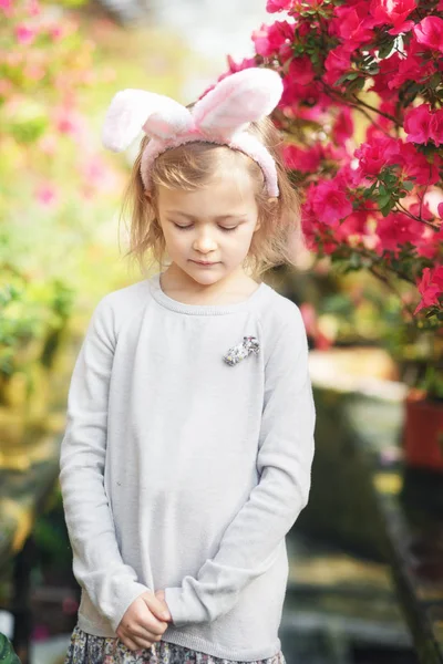 Linda chica divertida con orejas de conejo de Pascua en el jardín. concepto de Pascua. Riendo niño en la búsqueda de huevos de Pascua . —  Fotos de Stock