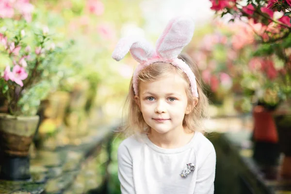 Linda chica divertida con orejas de conejo de Pascua en el jardín. concepto de Pascua. Riendo niño en la búsqueda de huevos de Pascua . —  Fotos de Stock