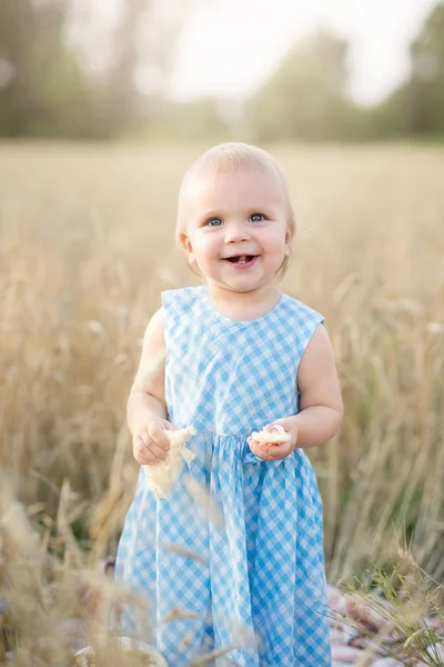 Mignonne petite fille heureuse dans le champ de blé sur une chaude journée d'été — Photo