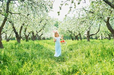 Paskalya yumurtaları ve bahçede tavşan kulakları ile sevimli komik kız. paskalya kavramı. Paskalya yumurtası avında gülen çocuk