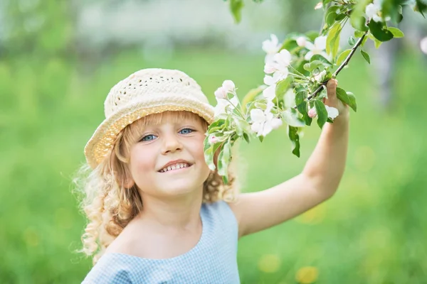 Flicka som sniffar blommor av äppelträdgård. trädgård med blommande träd — Stockfoto