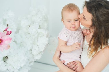 Güzel genç anne kucağında bir bebekle mutlu bir aile, annelik kavramı duruyor