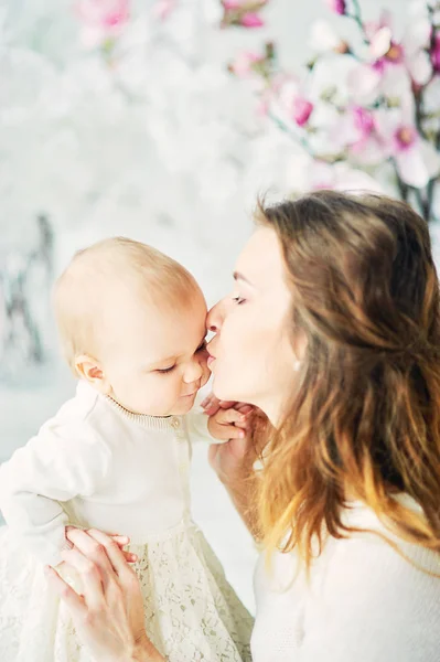 Schöne junge Mutter mit einem Baby auf dem Arm steht das Konzept einer glücklichen Familie, Mutterschaft — Stockfoto