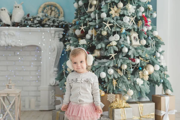 Beautiful girl near decorated Christmas tree with toy wooden rocking horse. Happy new year. Portrait little girl — Stock Photo, Image