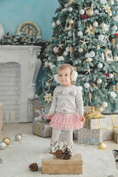 Beautiful girl near decorated Christmas tree with toy wooden rocking horse. Happy new year. Portrait little girl — Stock Photo, Image