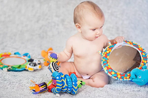 Bebê deitado no tapete em desenvolvimento. tocando em Mobile. brinquedos educativos. Doce criança rastejando e brincando com brinquedos no tapete — Fotografia de Stock