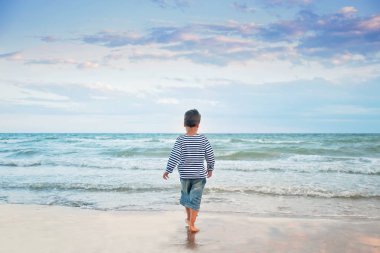 sahil de sahilde çalışan çizgili tank top çocuk, Yaz tatil konsepti