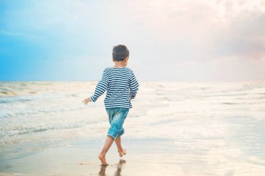 sahil de sahilde çalışan çizgili tank top çocuk, Yaz tatil konsepti