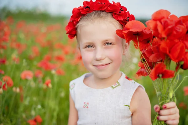 Ukrainian Beautiful girl in vyshivanka with wreath of flowers in a field of poppies and wheat. outdoor portrait in poppies. girl in embroidery. — Stock Photo, Image