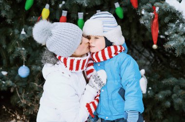 Anne ve oğlu bir kış parkı açık Noel ağacı süslemeleri. Hediyeler ve Noel ağaçları.