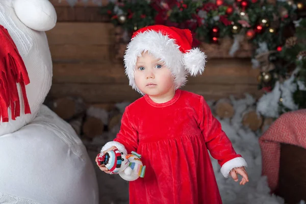 Little girl in red dress at a home interior waiting for Santa. — Stock Photo, Image