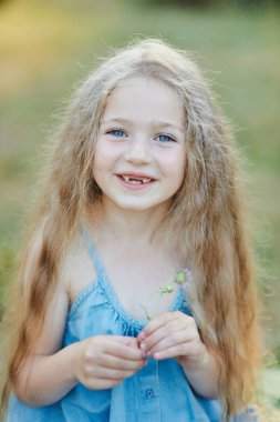 İki ön dişi olmadan beyaz dişlerini gösteren gülümseyen güzel sarışın beyaz kızın portresini yakından çek. Neşeli çocuk.