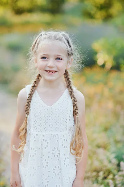 Lähikuva muotokuva kaunis iloinen blondi valkoihoinen tyttö hymyilee osoittaa valkoiset hampaat ilman kahta etuhampaat. Iloinen lapsi — kuvapankkivalokuva