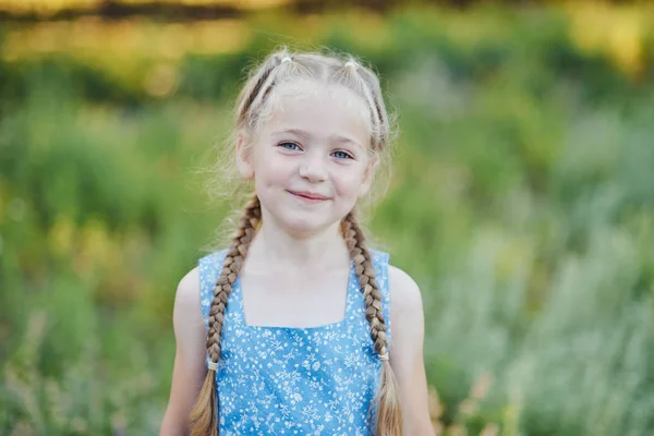 Liten flicka i lavendelfält. barn fantasi. Leende flicka sniffa blommor i sommar lila lavendelfält. — Stockfoto