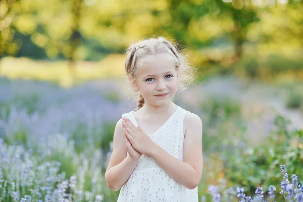 Маленька дівчинка в лавандовому полі. діти фантазії. Усміхнена дівчина нюхає квіти в літньому фіолетовому лавандовому полі . — стокове фото
