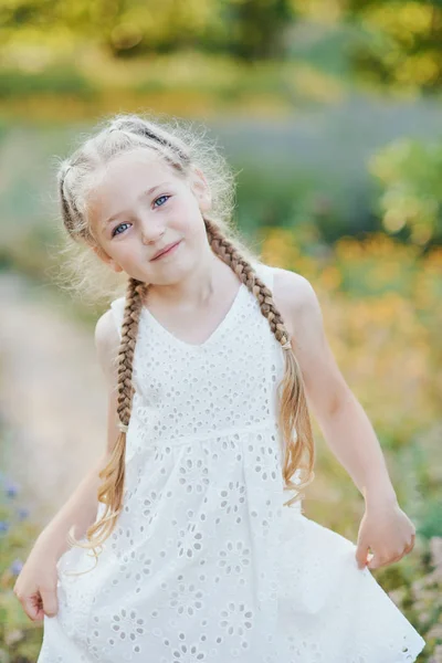 Liten flicka i lavendelfält. barn fantasi. Leende flicka sniffa blommor i sommar lila lavendelfält. — Stockfoto