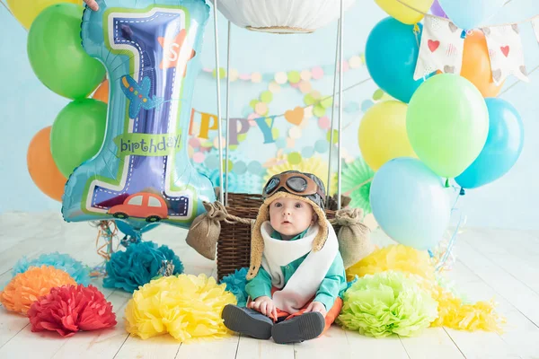 çocuğun ilk doğum günü için dekorasyon, bir havacı tarzında pasta şut. bebek kameraya bakarak gülümsüyor. Bir balon pilotu olarak kutlayan sevimli kafkas erkek bebek portresi