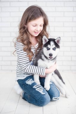 Beyaz bir arka plan üzerinde husky köpek yavrusu sarılma Sevimli küçük kız.