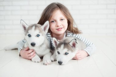 Beyaz bir arka plan üzerinde husky köpek yavrusu sarılma Sevimli küçük kız.