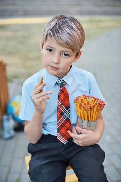 Portret van een gelukkige school jongen met potloden. Afscheids klok. dag van de kennis. begin van het schooljaar. — Stockfoto