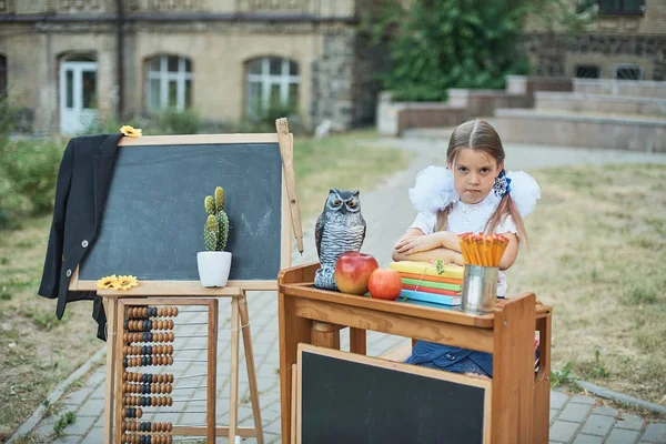 Smutna First Równiarka Siedzi Biurku Wyposażeniem Szkoły Schoolyard Powrót Szkoły — Zdjęcie stockowe