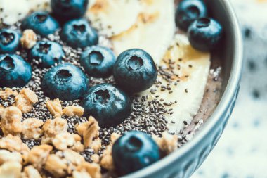 Sağlıklı kahvaltı Berry Smoothie kase kopya alanı ile muz, granola, yaban mersini ve Chia tohumları ile tepesinde