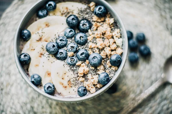 Cuenco saludable de batido de bayas de desayuno cubierto con plátano, granola, arándanos y semillas de chía con espacio para copiar — Foto de Stock