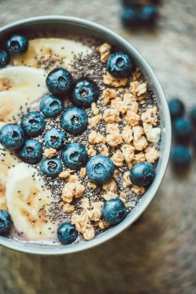 Gesunde Frühstücksbeeren-Smoothie-Schüssel mit Banane, Müsli, Blaubeeren und Chiasamen mit Kopierraum — Stockfoto