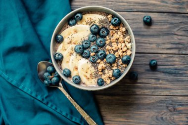 Sağlıklı kahvaltı Berry Smoothie kase kopya alanı ile muz, granola, yaban mersini ve Chia tohumları ile tepesinde