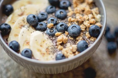 Sağlıklı kahvaltı Berry Smoothie kase kopya alanı ile muz, granola, yaban mersini ve Chia tohumları ile tepesinde