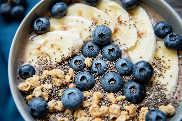 Gesunde Frühstücksbeeren-Smoothie-Schüssel mit Banane, Müsli, Blaubeeren und Chiasamen mit Kopierraum — Stockfoto