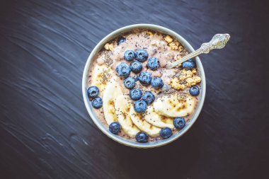 Sağlıklı kahvaltı Berry Smoothie kase kopya alanı ile muz, granola, yaban mersini ve Chia tohumları ile tepesinde