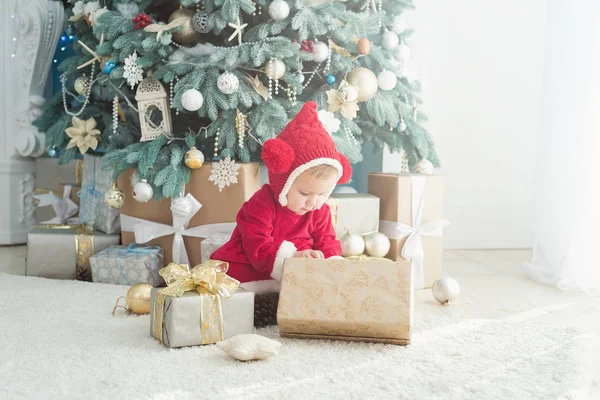 크리스마스 트리의 배경에 사이에 앉아있는 의상에 — 스톡 사진