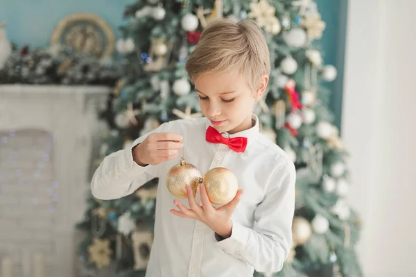 Маленький Мальчик Держащий Блестящие Безделушки Стоя Декоративной Комнате Фоне Рождественской — стоковое фото