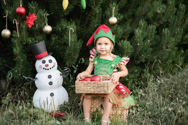 의상을 소녀는 상자를 정원에서 크리스마스 트리와 눈사람 근처에 줄리에서 크리스마스의 — 스톡 사진