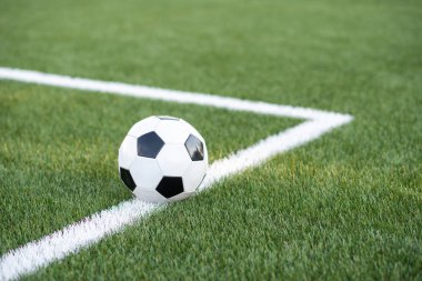 Futbol stadyumunun yeşil çim üzerinde geleneksel siyah beyaz top