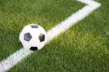 Futbol stadyumunun yeşil çim üzerinde geleneksel siyah beyaz top