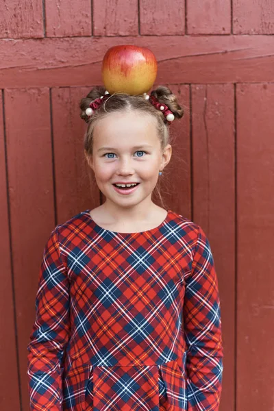 Gelukkig Schoolmeisje Met Rode Appel Hoofd Poseren Rode Houten Achtergrond — Stockfoto